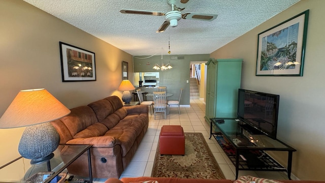 living room with a textured ceiling, light tile patterned floors, and ceiling fan