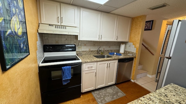 kitchen featuring white appliances, sink, white cabinetry, light stone counters, and light tile patterned floors