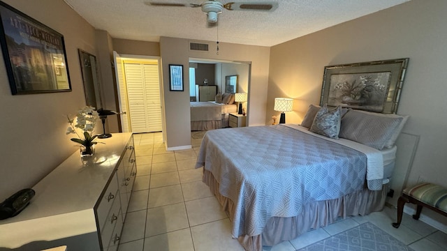 tiled bedroom featuring ceiling fan and a textured ceiling