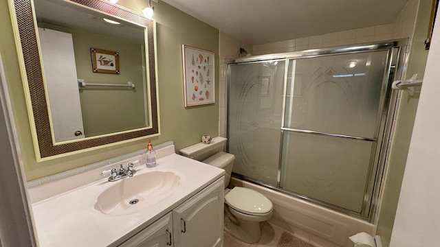 full bathroom featuring vanity, bath / shower combo with glass door, and toilet