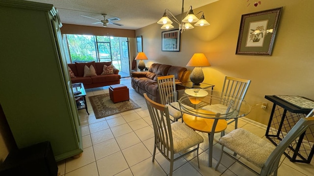 dining area with a textured ceiling, ceiling fan with notable chandelier, and light tile patterned floors