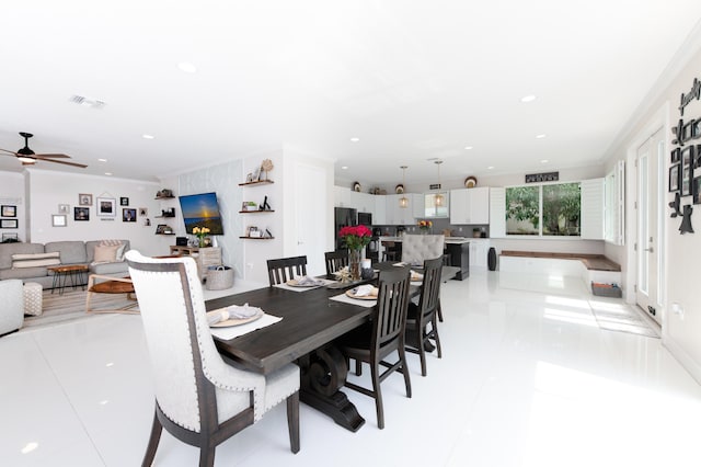 kitchen featuring black appliances, ornamental molding, a kitchen breakfast bar, and a sink