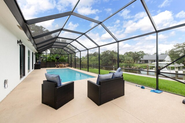 view of pool featuring a patio area, a fenced in pool, a water view, a lawn, and glass enclosure