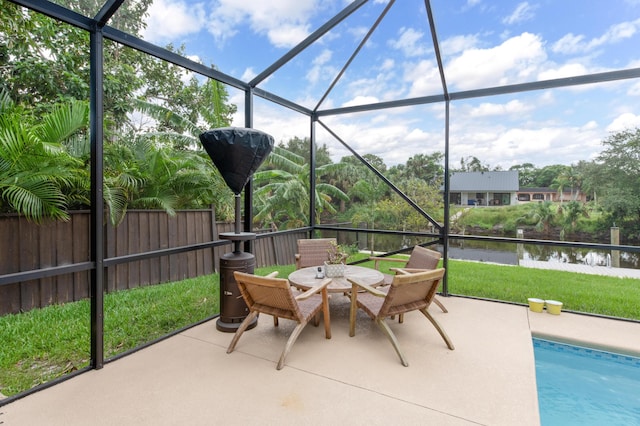 view of patio featuring a lanai, a water view, outdoor dining area, and a fenced in pool