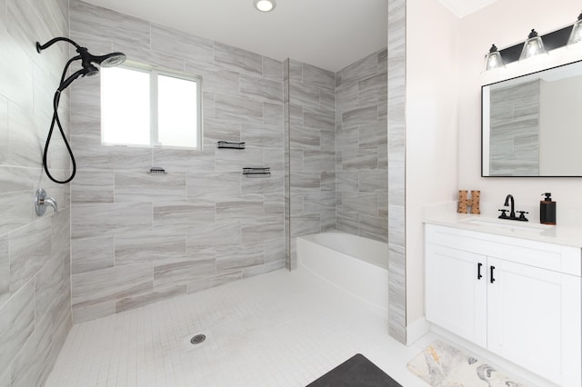 bathroom featuring tiled shower and vanity
