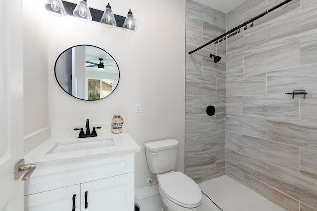 bathroom featuring toilet, vanity, tile patterned floors, and tiled shower