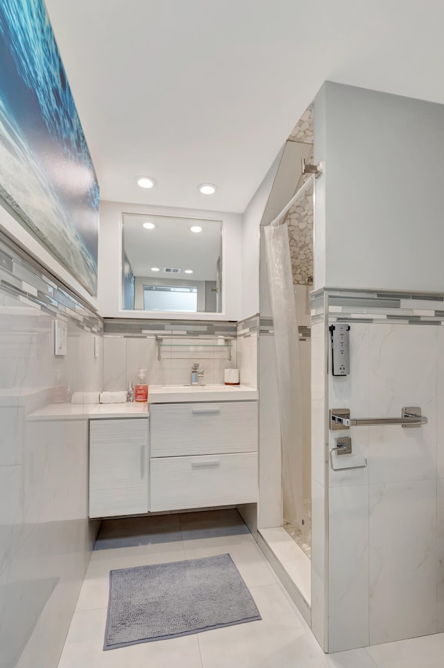 bathroom featuring vanity, a tile shower, and tile patterned floors