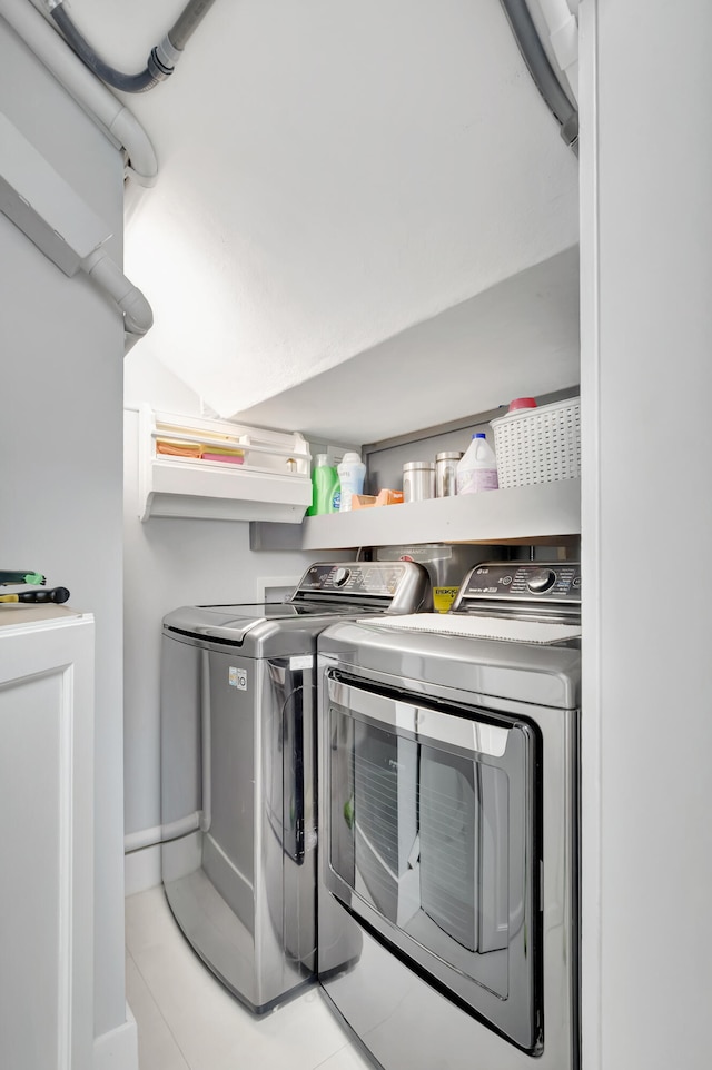 laundry room with washer and dryer and light tile patterned floors