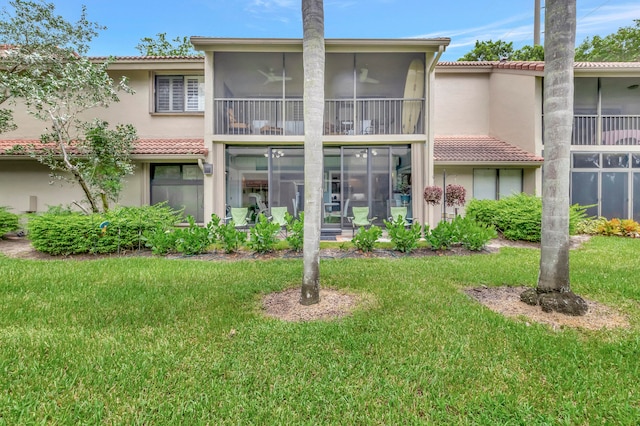 rear view of property with a sunroom and a lawn