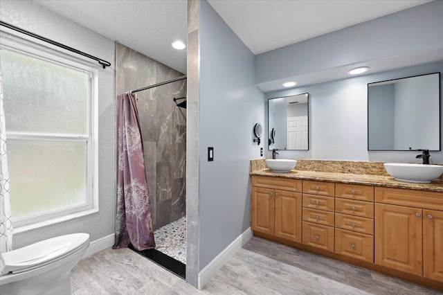 bathroom with toilet, a wealth of natural light, hardwood / wood-style floors, curtained shower, and vanity