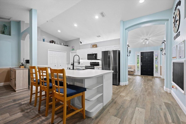 kitchen with a kitchen breakfast bar, sink, black appliances, white cabinets, and light hardwood / wood-style floors