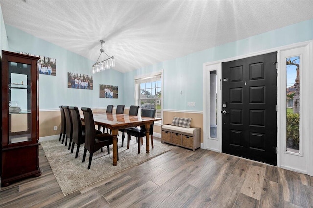 dining space featuring a notable chandelier, a textured ceiling, and hardwood / wood-style floors