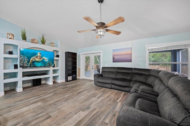 living room with a wealth of natural light, french doors, wood-type flooring, and a textured ceiling