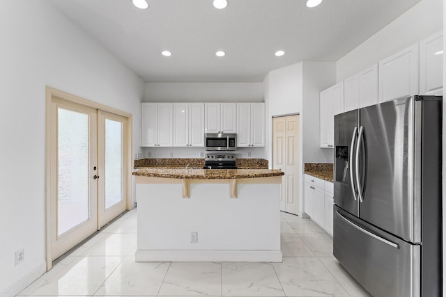 kitchen with white cabinetry, french doors, appliances with stainless steel finishes, and dark stone counters