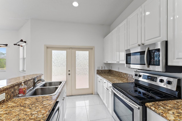 kitchen featuring white cabinetry, lofted ceiling, sink, and stainless steel appliances