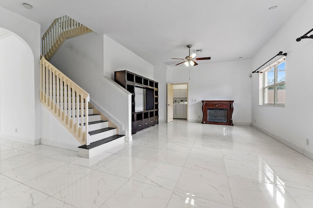 unfurnished living room with ceiling fan