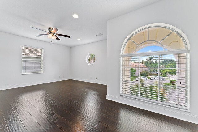 spare room with dark wood-type flooring and ceiling fan