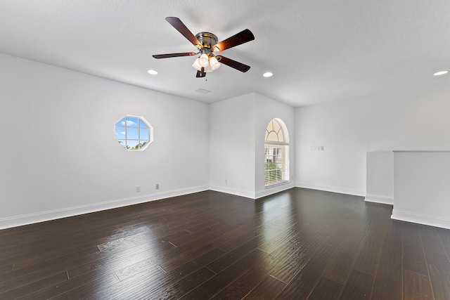 spare room with dark wood-type flooring, ceiling fan, and a textured ceiling