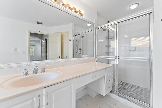 bathroom with walk in shower, vanity, and a healthy amount of sunlight