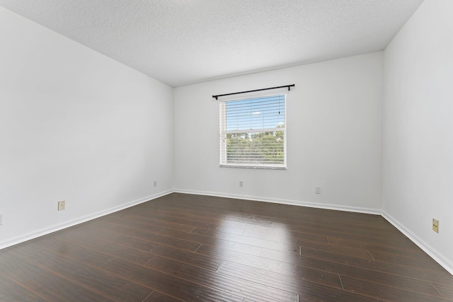 unfurnished room featuring dark wood-type flooring and a textured ceiling