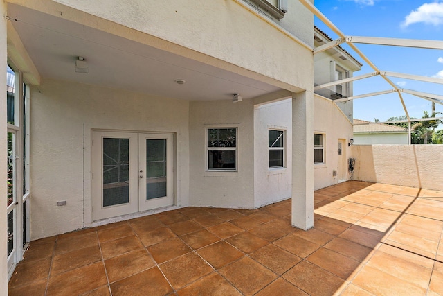 view of patio featuring french doors and glass enclosure