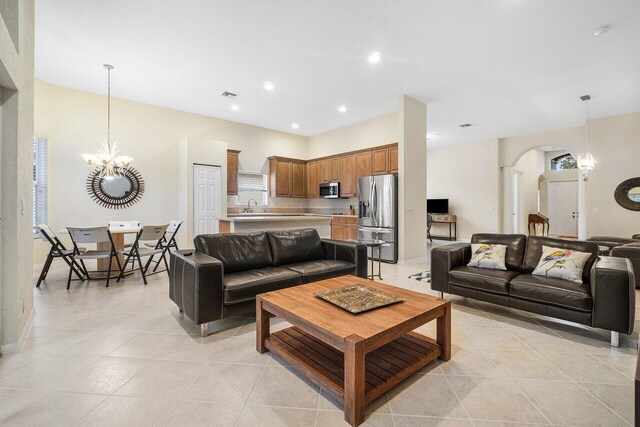 living room featuring a notable chandelier, sink, and light tile patterned floors