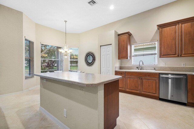 kitchen with an inviting chandelier, stainless steel dishwasher, sink, and a wealth of natural light