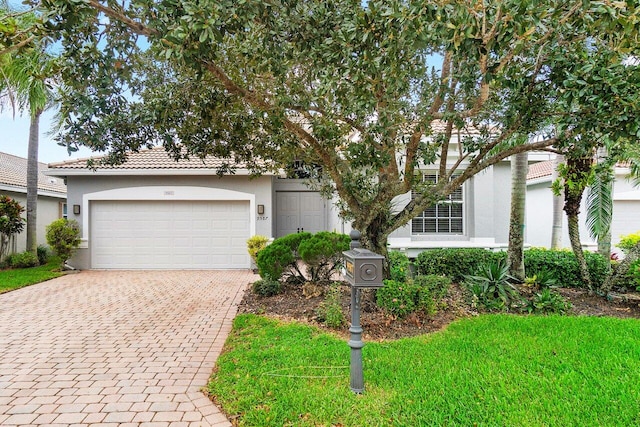 9587 Positano Way, Lake Worth, FL 33467 - view of front of property featuring stucco siding, decorative driveway, an attached garage, a front lawn, and a tile roof