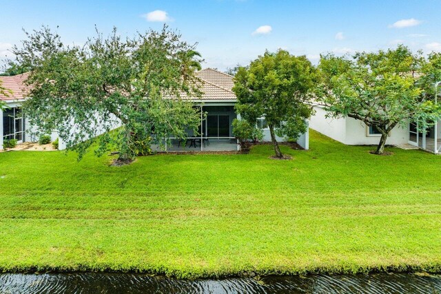 view of yard with a water view and a sunroom