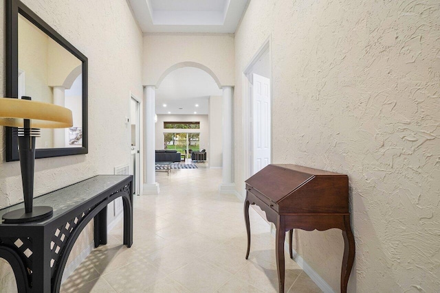 9587 Positano Way, Lake Worth, FL 33467 - corridor with arched walkways, a textured wall, baseboards, and light tile patterned floors
