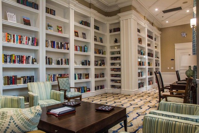 living area featuring ornamental molding, carpet flooring, and built in features