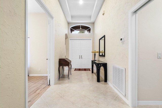 9587 Positano Way, Lake Worth, FL 33467 - corridor with a textured wall, light tile patterned floors, baseboards, and a raised ceiling