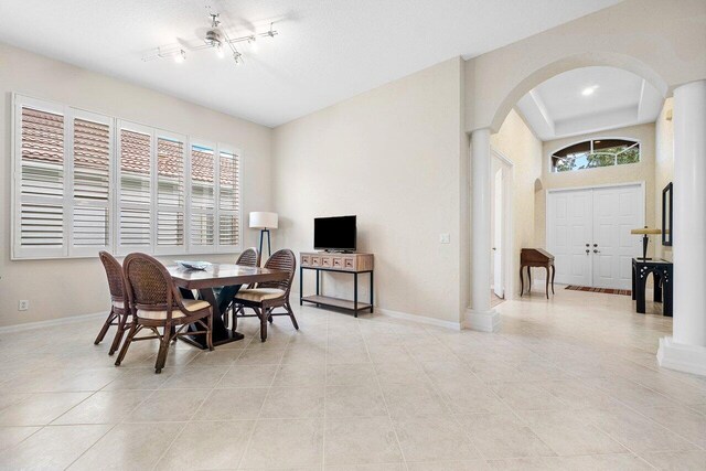 dining room featuring light tile patterned floors and decorative columns