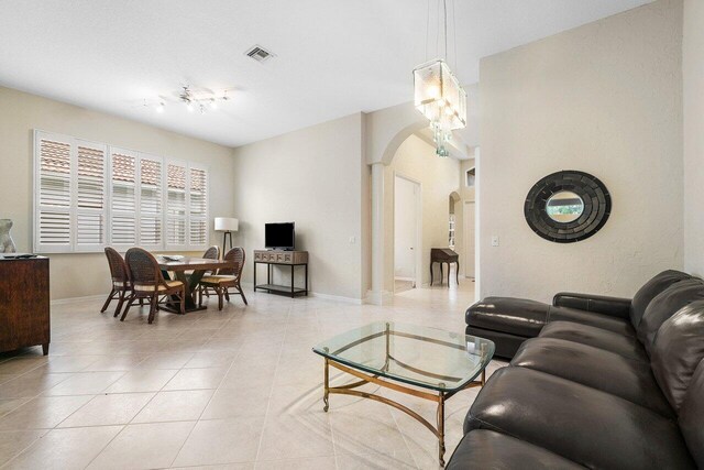 living room featuring ornate columns and light tile patterned floors