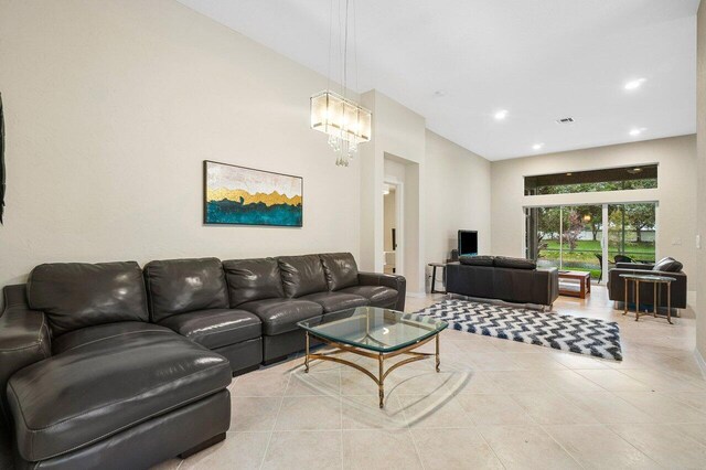 tiled living room with a notable chandelier