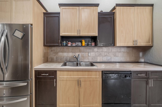 kitchen with dishwasher, backsplash, sink, light brown cabinetry, and stainless steel refrigerator