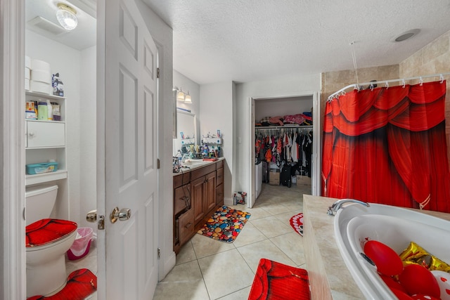 full bathroom featuring a textured ceiling, independent shower and bath, toilet, vanity, and tile patterned flooring