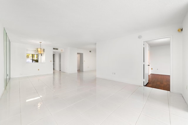 6093 Pointe Regal Cir Unit 106, Delray Beach, FL 33484 - spare room featuring a chandelier and tile patterned flooring