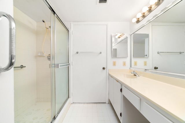 bathroom with vanity, walk in shower, and tile patterned flooring