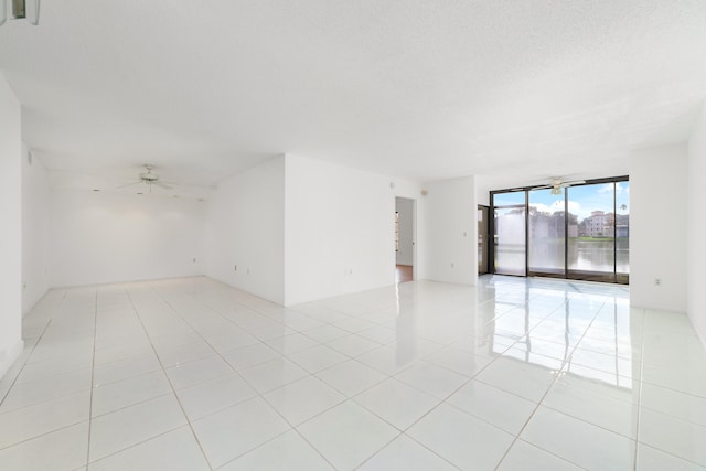 empty room with light tile patterned floors and ceiling fan