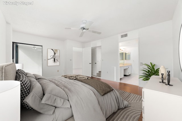 6093 Pointe Regal Cir Unit 106, Delray Beach, FL 33484 - bedroom with light wood-style floors, ceiling fan, and ensuite bath