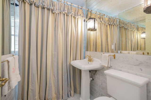 bathroom featuring toilet and tile walls