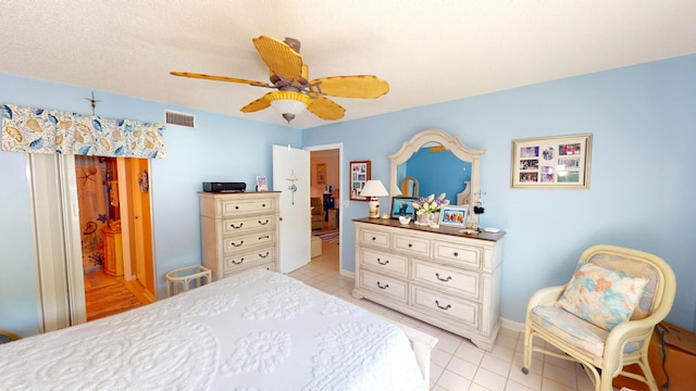 bedroom featuring ceiling fan, a textured ceiling, and light tile patterned flooring