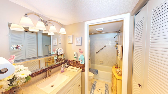 full bathroom with toilet, tiled shower / bath combo, vanity, and a textured ceiling