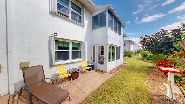 rear view of property featuring a patio and a lawn