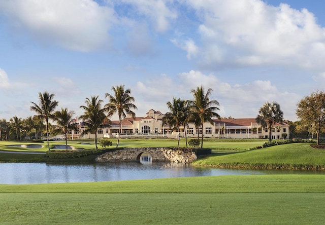 surrounding community with a water view and a lawn