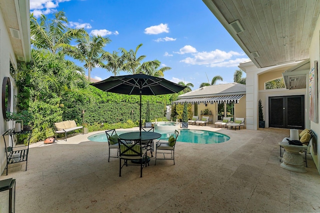 view of swimming pool featuring an in ground hot tub, a patio, and french doors