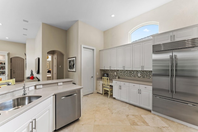 kitchen featuring decorative backsplash, sink, white cabinetry, and stainless steel appliances