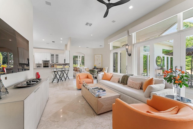 living room with ceiling fan and a wealth of natural light