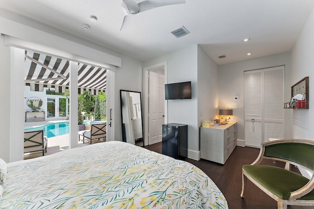 bedroom featuring black refrigerator, ceiling fan, dark hardwood / wood-style floors, access to exterior, and a closet